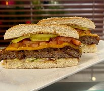 Auf dem Bild sind zwei Burgerhälften zu sehen. Diese sind auf einem Teller angerichtet. Sie sehen lecker aus.