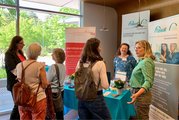 Sechs Frauen im Gespräch vertieft am Stand der FAW 