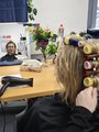 Kundin mit Lockenwickler Foto: Eine Kundin mit Lockenwicklern vor einem Spiegel