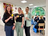 3 lächelnde Frauen mit Gläsern in der Hand