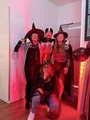 Gruppen-Foto im roten Licht: Vier Mitarbeitende und Teilnehmende in gruseligen Kostümen.