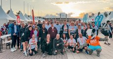 Foto: Das Team von faw und BTZ im Abendlicht und Stadion mit Maskottchen der DAK