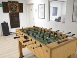Zu sehen sind ein Tischkicker und eine Dartscheibe die an der Wand befestigt wurde.