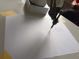 Foto eines Roboterarmes beim Schreiben eines Wortes. 