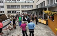 Foto von der Eröffnung des Ostermarktes. Viele Menschen stehen auf der Terrasse um die Stände des Marktes. 