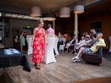Fachtagung Depression Foto: Viele Besucher*innen, die um Stehtische mit Getränken sitzen und stehen.