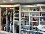 Neuer Trainingsbereich picSELL: Regale mit Damen- und Herrenkleidung sowie drei Regale mit Büchern und Kleingeräten sowie Dekorationsmaterial.