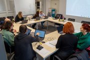 Einblick im Ergotherapeut*innen Workshop des BTZ Gera Foto: Schulungssituation mit mehreren Fachleuten und einer Präsentation im Schulungsraum.