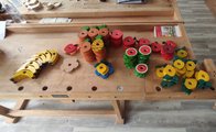 Buntes Obst und Blumen als Steckteile aus Holz Foto: Buntes Obst und Blumen als Steckteile aus Holz auf einer Werkbank.