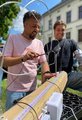 Foto: Zwei Männer probieren sich während des Sommerfestes am Spiel "Heißer Draht".