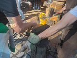 Eisen bei den Bearbeitung Zwei Teilnehmende bearbeiten Eisen auf einem Amboss