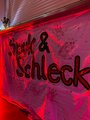 Foto in rotem Licht auf dem der Werbebanner am Kiosk mit der Aufschrift Spuk & Schleck zu sehen ist. 