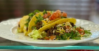 Auf einem Teller befinden sich drei mexikanische Beef Tacos.