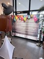 Hintergrundwand zur Fotobox Foto: Fotobox-Hintergrundleinwand, belichtet durch Lichtstrahler: Bretterboden und Bretterrückwand mit bunten Luftballons.