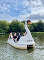 Foto: Schwanen-Tretboot mit mehrere BTZ-Mitarbeitenden fahren bei sommerlichem Wetter über den See. 