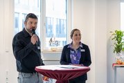 Thomas Eiweleit-Heise am Mikrofon, daneben steht Sandra Grimmer. 
