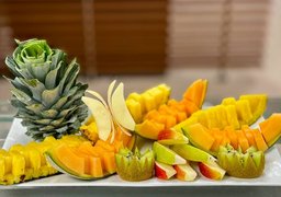 In Nahaufnahme ist ein Teller zu sehen. Darauf liegen verschiedene Obstsorten wie Kiwi, Ananas und Mango. Diese sind besonders schön aufgeschnitten.