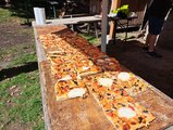 Pizza zur Mittagsversorgung Langes Holzbrett mit selbstgemachter Pizza