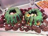 Foto: Kuchenbuffet mit Schokoladenrührkuchen, verziert mit grünem Schleim und Augen.