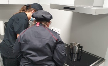 Es sind eine Teilnehmende und eine Berufstrainerin zusehen, die gemeinsam Kekse in der neuen Küchennische des BTZ Gera herstellen.