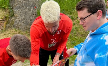 Zwei Spieler und ein Teilnehmer während der Autogrammstunde