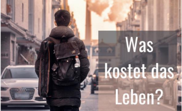 Foto: Auf dem Foto geht ein junger Mann eine Straße entlang. Er ist nur von hinten zu sehen. Am Straßenrand parken Autos.