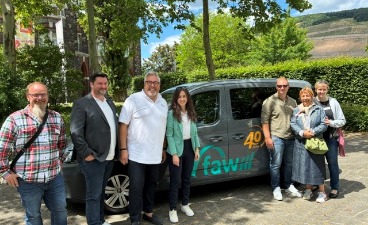 Foto: Das Team des BTZ Kaiserslautern (sieben Personen) vor dem neuen, grauen mit großem faw-Logo versehenen Poolfahrzeug,