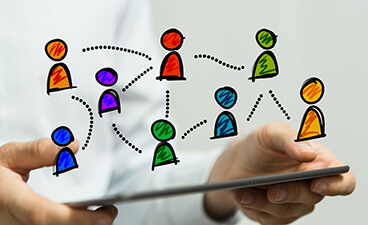 Illustration Vernetzung: Person hält ein Tablet, darauf gezeichnete Spielfiguren, verbunden durch gestrichelte Linien.