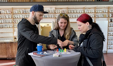 Drei Personen am Stand des TTZ testen ein Spiel zum kognitiven Training
