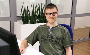 Der Autor des Reflektionsberichtes sitzt am Schreibtisch im Lehrbüro des BTZ Plauen