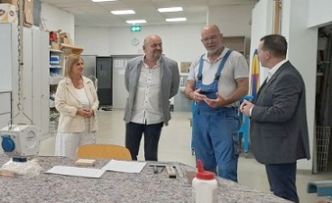 Foto: Ausbilder und zwei Mitglieder der Leitung im Gespräch mit dem Landrat
