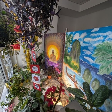 Draufsicht auf das dekorierte Schaufenster. Zu sehen ist ein Bild eines Strandes, sowie eines Buddhas. Im Vordergrund befindet sich Sand und verschiedene Pflanzen
