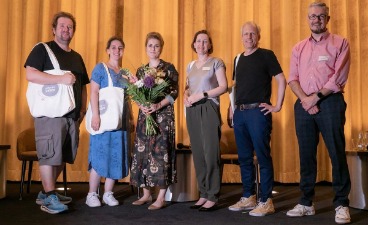 Foto aller Teilnehmenden der Podiumsdiskussion auf der Bühne