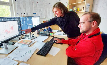 Teaserbild: Alexander Wolff am Schreibtisch vorm PC mit einer Kollegin