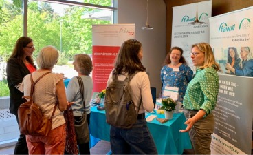 Sechs Frauen im Gespräch vertieft am Stand der FAW 